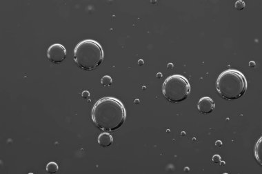 Karanlık arka plan. Projeler için hava kabarcıkları, yağ, bal, bira, meyve suyu, şampuan. Siyah ve beyaz