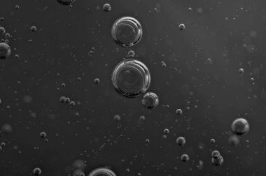 Karanlık arka plan. Projeler için hava kabarcıkları, yağ, bal, bira, meyve suyu, şampuan. Siyah ve beyaz 