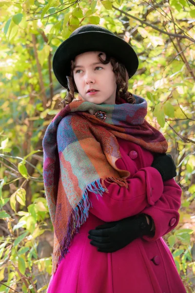 Portre kız güneşli bir sonbahar gün içinde parlak koyu kırmızı paltolu üstün