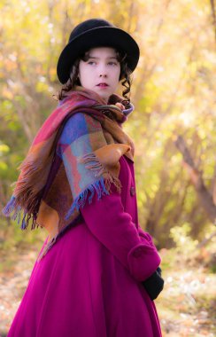 Portre kız güneşli bir sonbahar gün içinde parlak koyu kırmızı paltolu üstün