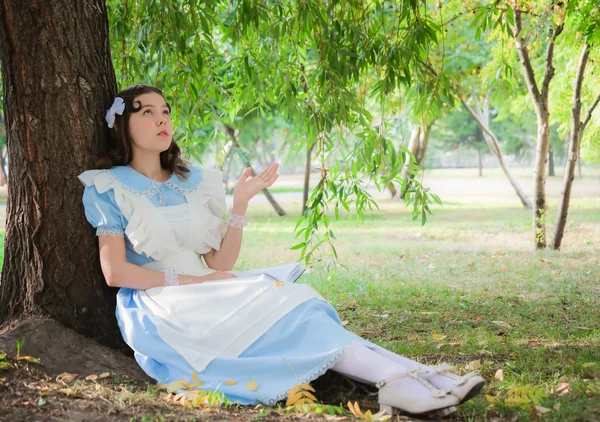 Chica en la imagen de la heroína de un hada sentada debajo de un árbol —  Fotos de Stock