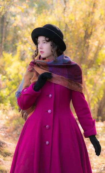 Ritratto ragazza in un luminoso cappotto cremisi in soleggiata giornata autunnale outdo — Foto Stock