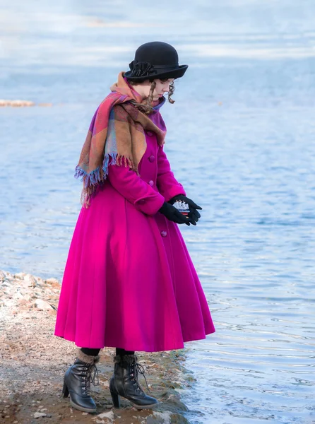 Chica en la orilla del estanque lanza barco de juguete —  Fotos de Stock