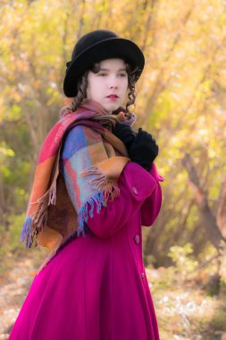 Portre kız parlak koyu kırmızı paltolu rüzgarda donuyor.