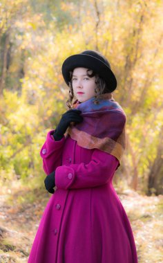 Portre kız güneşli bir sonbahar gün içinde parlak koyu kırmızı paltolu üstün