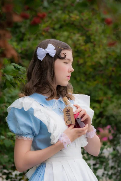 Meisje in beeld van sprookje heldin dranken drinken van glazen fles — Stockfoto
