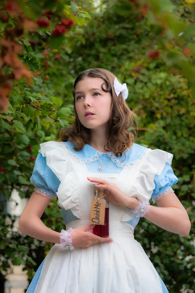 Meisje in beeld van sprookje heldin dranken drinken van glazen fles — Stockfoto