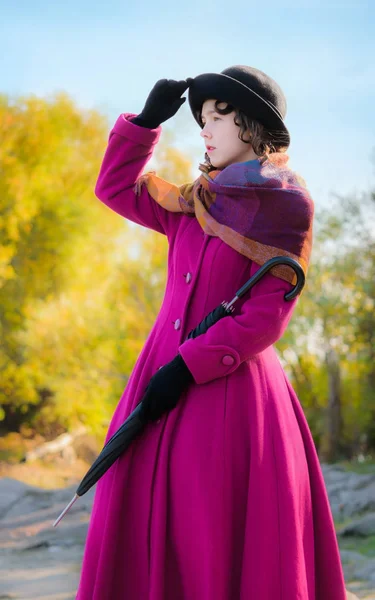 Fille dans un manteau cramoisi brillant regarde dans la distance — Photo