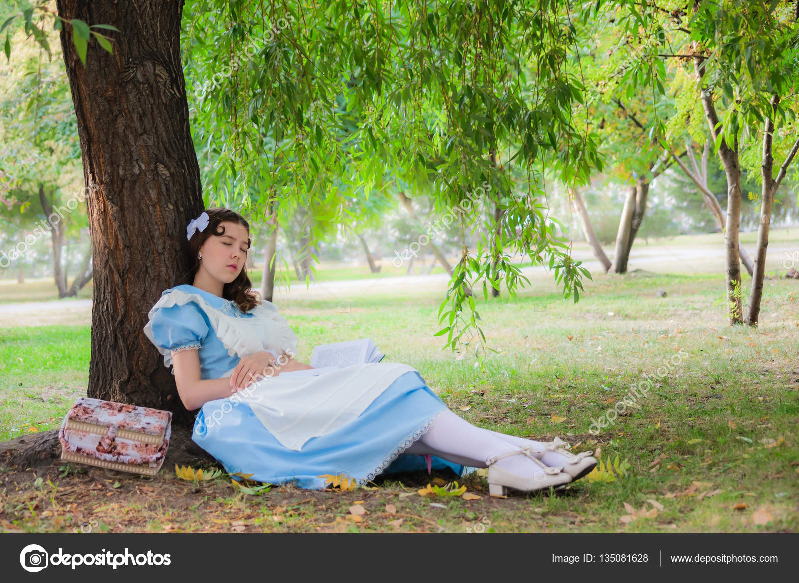 Girl pupil fell sleep under a tree with a book. — Stock Photo © LuGrish