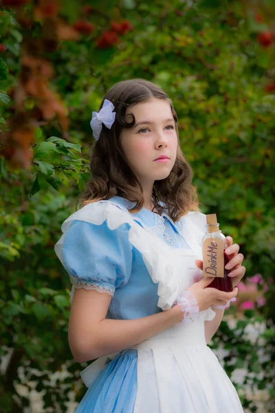 Mädchen im Bild der Märchenheldin zweifelt und hält ein Glas Wasser in der Hand — Stockfoto