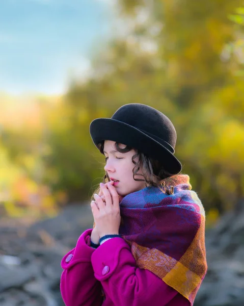 Girl warms hands breathing to warm up.