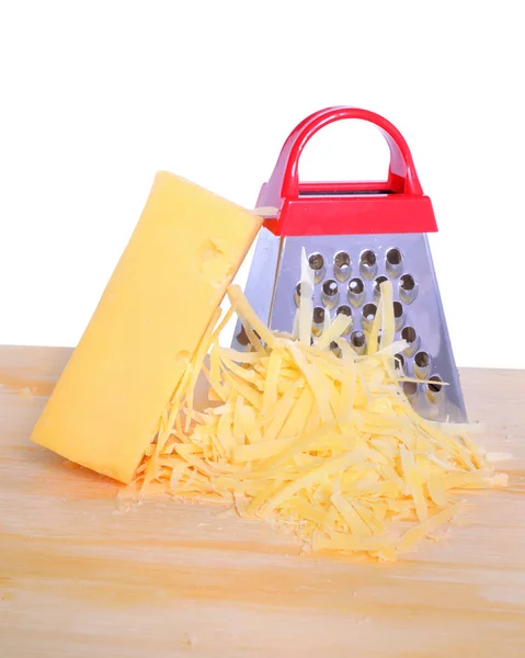 Rallador de queso de barra y queso rallado en tabla de cortar aislado — Foto de Stock