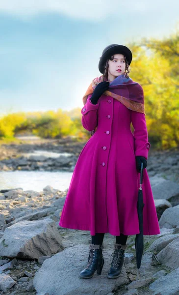 Chica con un abrigo carmesí brillante se dio la vuelta y mirando hacia otro lado . —  Fotos de Stock