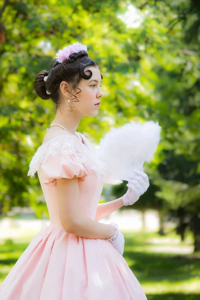 Romantic, charming girl fanning herself fan and with an attentiv — Stock Photo, Image