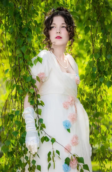 In een lange, elegante witte bruid meisjeskleding in een park. — Stockfoto