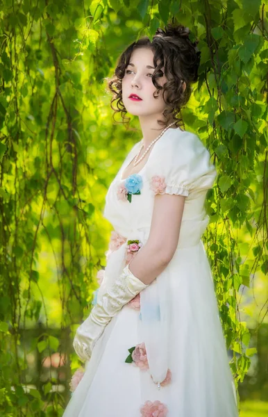 Femme dans une robe de mariée blanche longue et élégante dans un parc . Image En Vente