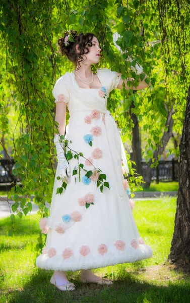 Vrouw in een lange, elegante witte bruid kleden in een park. — Stockfoto