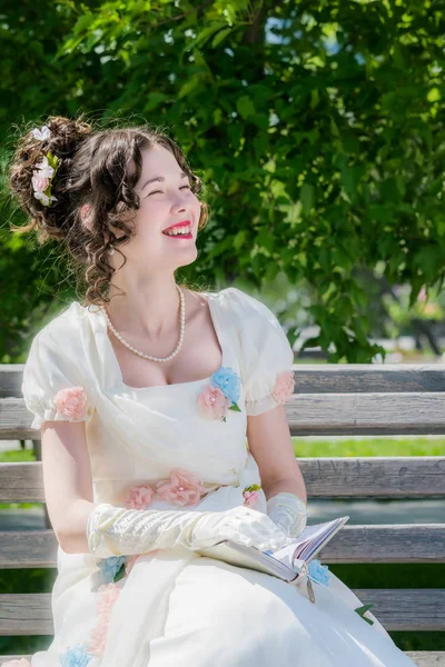 Gelukkig meisje in een lange witte bruid jurk met een glimlach is rea — Stockfoto
