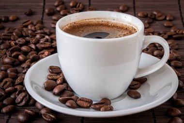 Kahve fincanı ve kahve çekirdekleri.