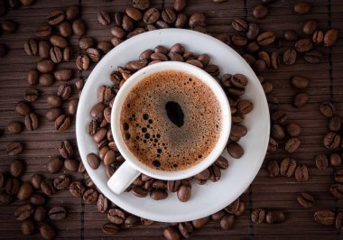 Kahve fincanı ve kahve çekirdekleri.