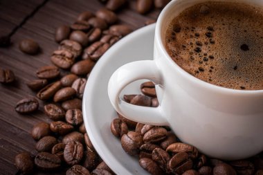 Kahve fincanı ve kahve çekirdekleri.