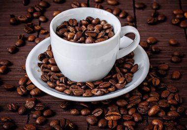 Kahve fincanı ve kahve çekirdekleri.