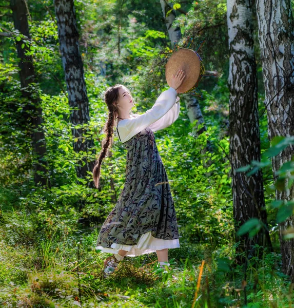 Chica bruja realiza un ritual de baile con una pandereta — Foto de Stock