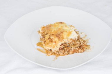 Beyaz arka planda kıymalı lazanya.