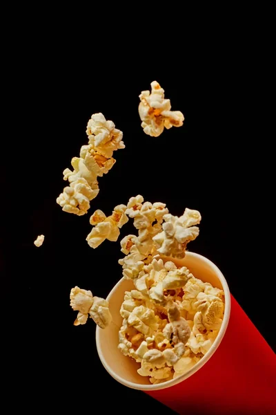 Popcorn, létající z kbelíku na černém pozadí — Stock fotografie