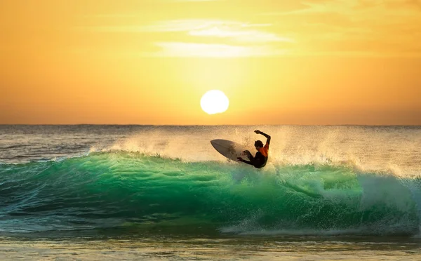 Surfer surfing on a wave at sunrise or sunset — Stock Photo, Image
