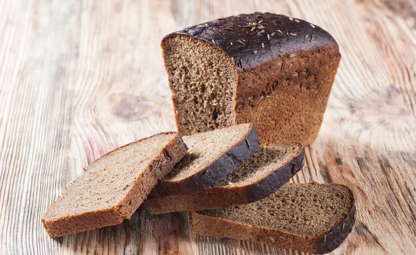 Темный хлеб на старом дереве — стоковое фото