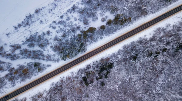 Landsvägen går igenom den vackra snön täckte landskap. Flygfoto. Drone fotografi — Stockfoto
