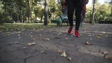 Sonbahar parkında yürüyen beyaz kadın.