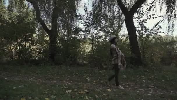 Una Giovane Bruna Con Cappello Occhiali Passeggia Nel Parco Autunnale — Video Stock