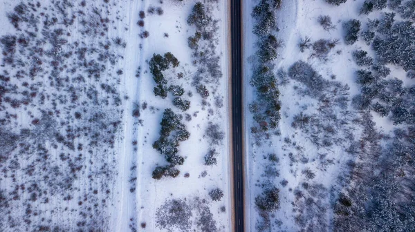 Загородная дорога, проходящая по красивым заснеженным пейзажам. Вид с воздуха. Фотография дронов — стоковое фото