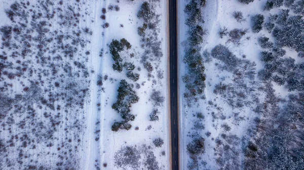 Camino de campo que pasa por los hermosos paisajes cubiertos de nieve. Vista aérea. Fotografía de drones —  Fotos de Stock