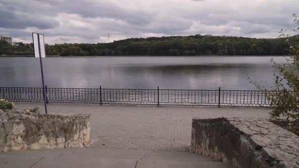 Mouvement de la caméra devant une promenade lacustre vide dans un parc municipal. Jour d'automne couvert .