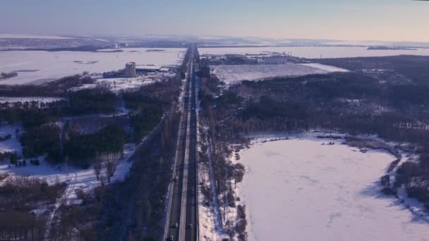 Vue de dessus de la circulation automobile sur l'autoroute d'hiver. Voitures et camions conduisant sur la route d'hiver à travers la forêt enneigée paysage aérien .