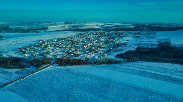 Воздушный вид деревни среди полей и лесов в зимний период. зимний пейзаж заснеженные поля и деревья в сельской местности. — стоковое фото