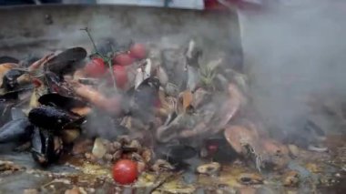 Asya sokak yemekleri. Deniz ürünleri karidesi, kalamar, ahtapot kızartma tavasında pişirme. Tavada deniz ürünleri pişirip karıştırmak.