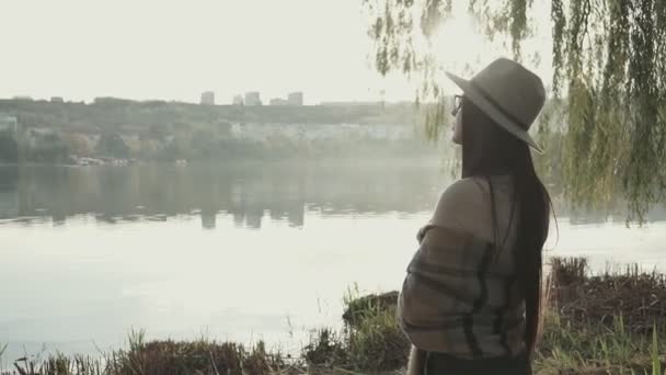 Расслабляющий Отдых Молодая Женщина Шляпе Стоит Озера Смотрит Вдаль Закат — стоковое видео