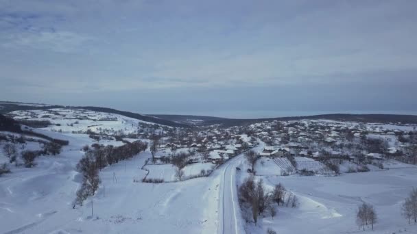 letecký pohled vesnice mezi poli a lesy v zimě. zimní krajina zasněžené pole a stromy na venkově.