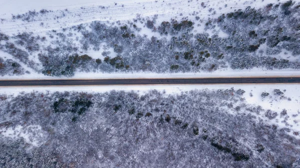 Landsvägen går igenom den vackra snön täckte landskap. Flygfoto. Drone fotografi — Stockfoto