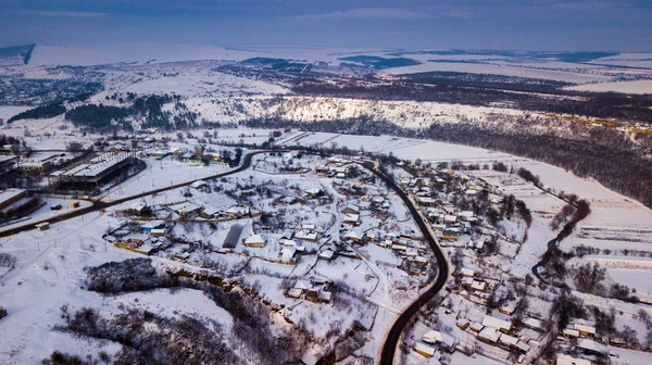 Vue aérienne village parmi les champs et les forêts en hiver. paysage hivernal champ enneigé et arbres à la campagne. — Photo