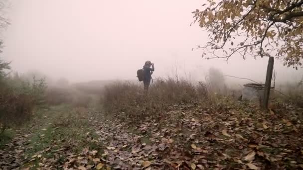 Mężczyzna Fotograf Robi Zdjęcia Strasznym Mglistym Lesie Mroczny Jesienny Deszczowy — Wideo stockowe