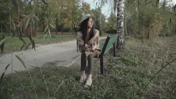 Pihentető Fiatal Kalapban Egy Padon Nézi Távolságot Lenyugvó Nap — Stock videók