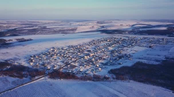 冬の畑や森の中の空中風景村 冬の風景雪が畑や田舎の木を覆い — ストック動画