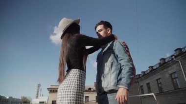 Şık bir adam ve kız sokakta kameranın önünde poz veriyorlar..