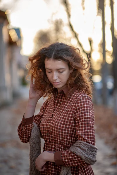 Soñando mujer joven con espectacular pelo rojo jengibre rizado mirando a la cámara posando al aire libre en la calle del centro. Retrato femenino . —  Fotos de Stock