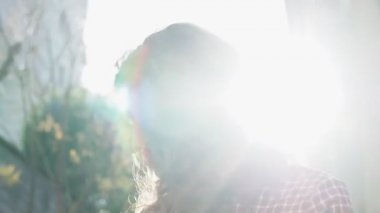 Olağanüstü kıvırcık kızıl saçlı genç bir kadın şehir merkezindeki sokakta kameraya bakıyor. Kadın portresi.